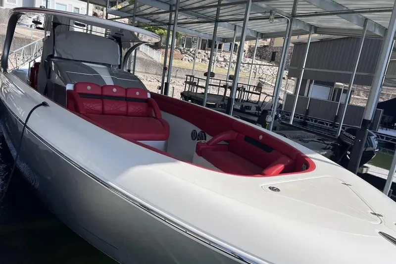 Slide: The Image of 2019 Mystic Powerboats M4200 with red seating, docked under a covered marina. - 24