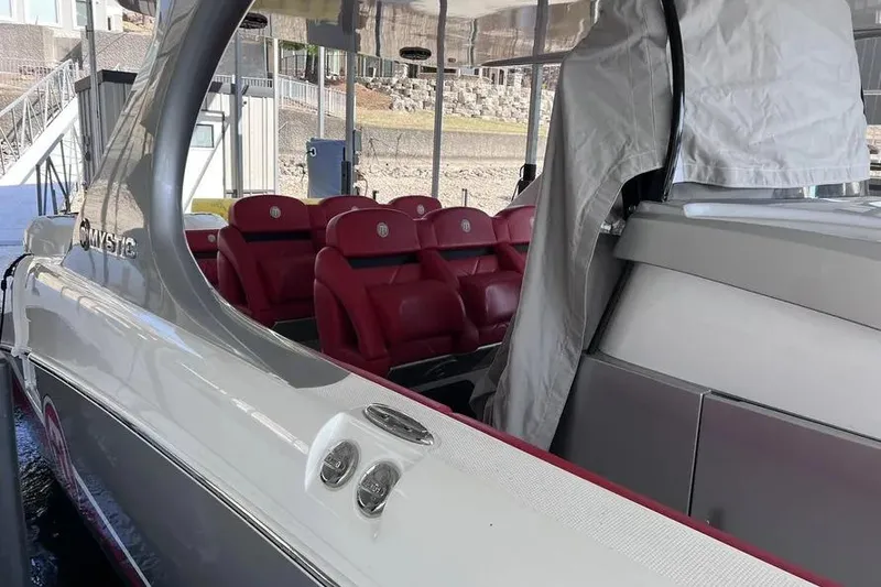 Slide: The Image of 2019 Mystic Powerboats M4200 with red seating, docked under a canopy. - 25