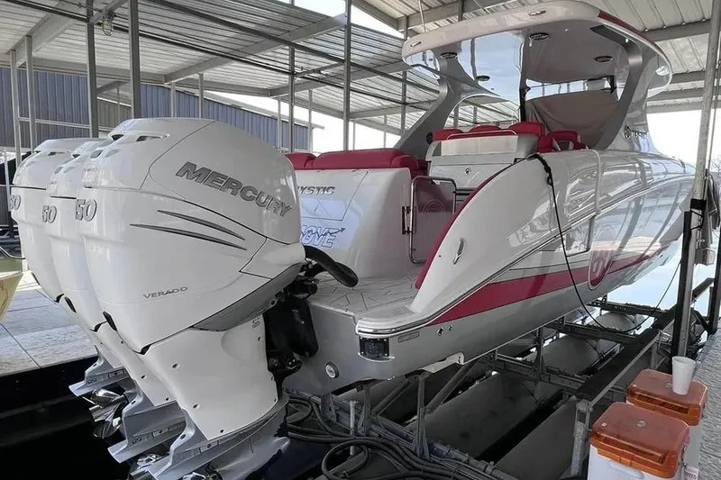 Slide: The Image of 2019 Mystic Powerboats M4200 with triple Mercury engines, docked under a covered marina. - 26