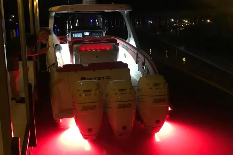 Slide: The Image of 2019 Mystic Powerboats M4200 illuminated at night with vibrant red lights. - 28