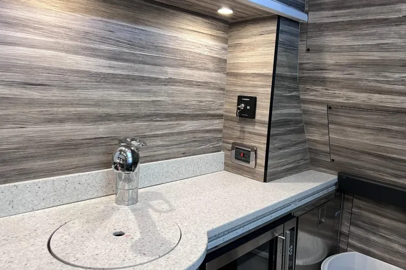 Slide: The Image of Modern interior of 2019 Mystic Powerboats M4200 with sleek countertop and wood paneling. - 29