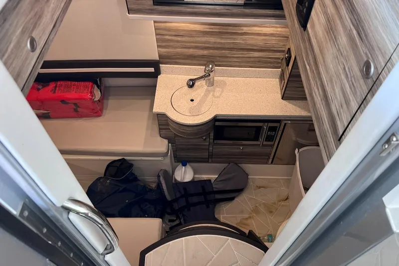 Slide: The Image of 2019 Mystic Powerboats M4200 cabin interior with sink, microwave, and storage. - 30