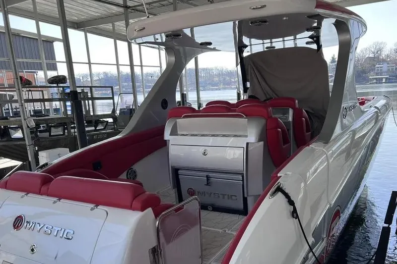 Slide: The Image of 2019 Mystic Powerboats M4200 with red seating, docked in a covered marina. - 4