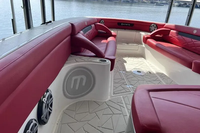 Slide: The Image of 2019 Mystic Powerboats M4200 interior with red seating and waterfront view. - 7
