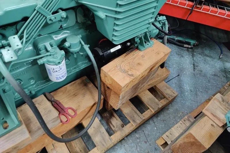 Slide: The Image of Green Mako 286 engine from 1991 on wooden blocks and pallet in workshop. - 16