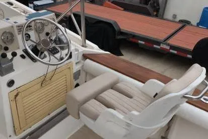 Slide: The Image of 1991 Mako 286 boat cockpit with steering wheel and cushioned seat. - 3