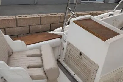 Slide: The Image of 1991 Mako 286 boat interior with cushioned seating and wooden accents. - 5