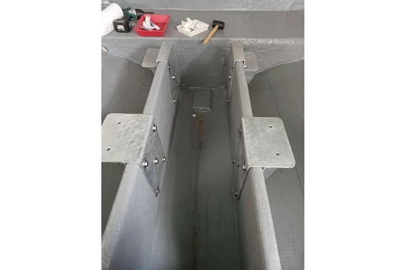 Slide: The Image of Interior view of a 1991 Mako 286 boat hull with metal brackets and tools. - 7