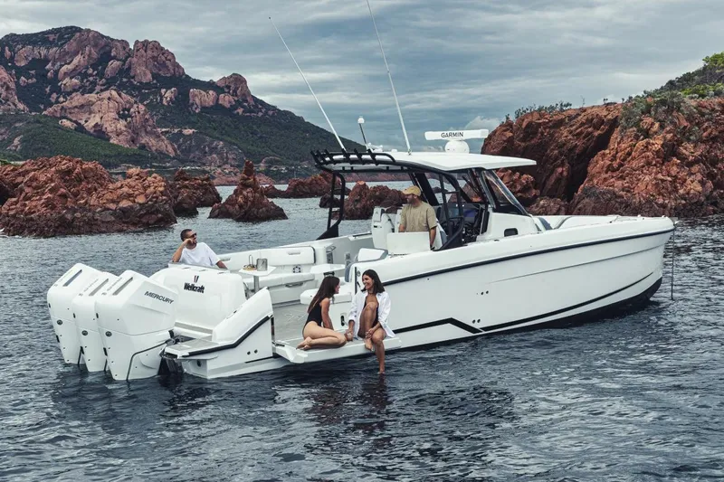 Slide: The Image of Manufacturer Provided Image: 2026 Wellcraft 38 T-Top boat cruising near rocky coastline with passengers enjoying the view. - 7