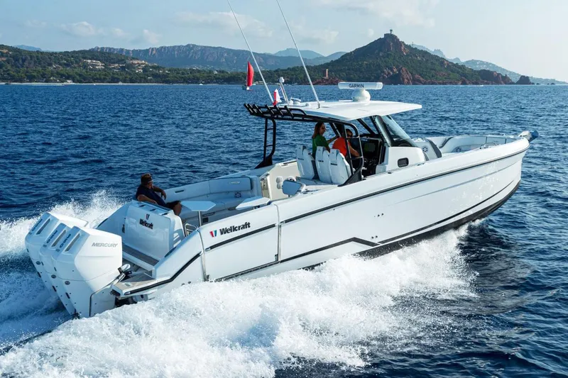 Slide: The Image of Manufacturer Provided Image: 2026 Wellcraft 38 T-Top boat cruising on ocean with scenic mountain backdrop. - 9
