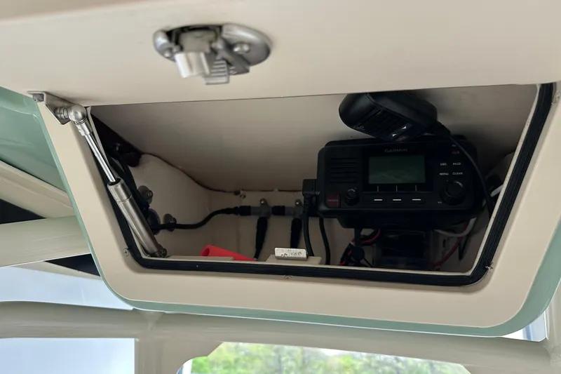 Slide: The Image of 2023 Grady-White Fisherman 236 boat electronics compartment with Garmin radio equipment. - 12