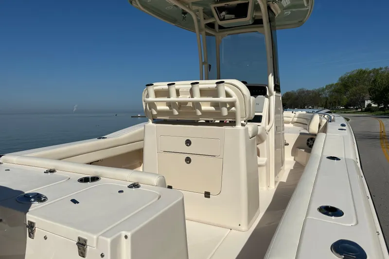 Slide: The Image of 2023 Grady-White Fisherman 236 boat interior with seating and storage, docked by a calm lake. - 9