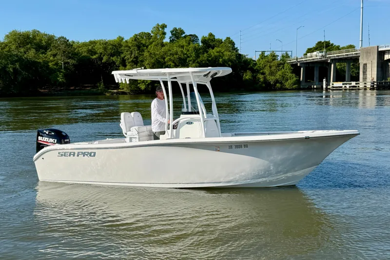 The Image of 2018 Sea Pro 219 Center Console boat on calm river near bridge. - 0
