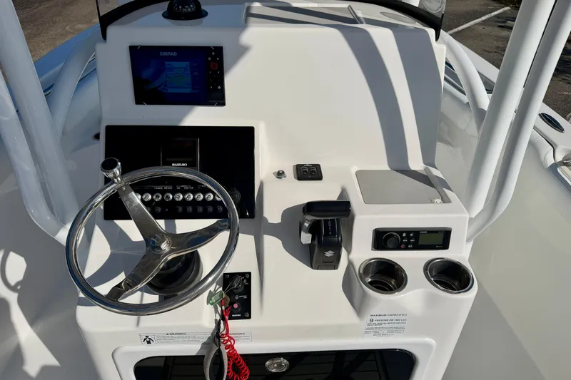 Slide: The Image of 2018 Sea Pro 219 Center Console dashboard with steering wheel, controls, and cup holders. - 14