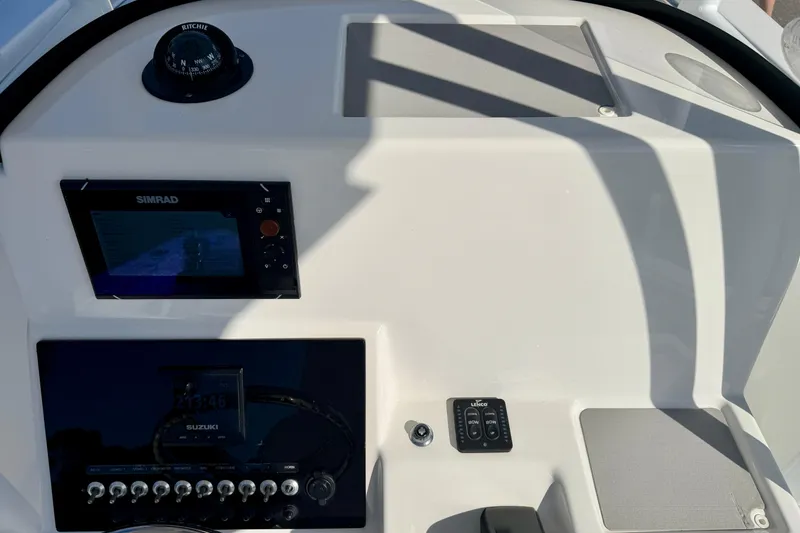 Slide: The Image of 2018 Sea Pro 219 Center Console dashboard with Simrad display and Suzuki controls. - 15