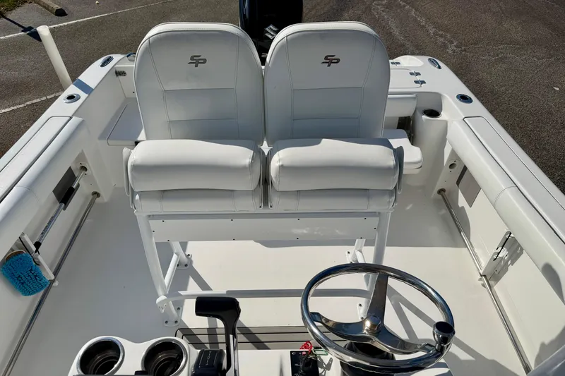 Slide: The Image of 2018 Sea Pro 219 Center Console boat interior with dual white seats and steering wheel. - 25