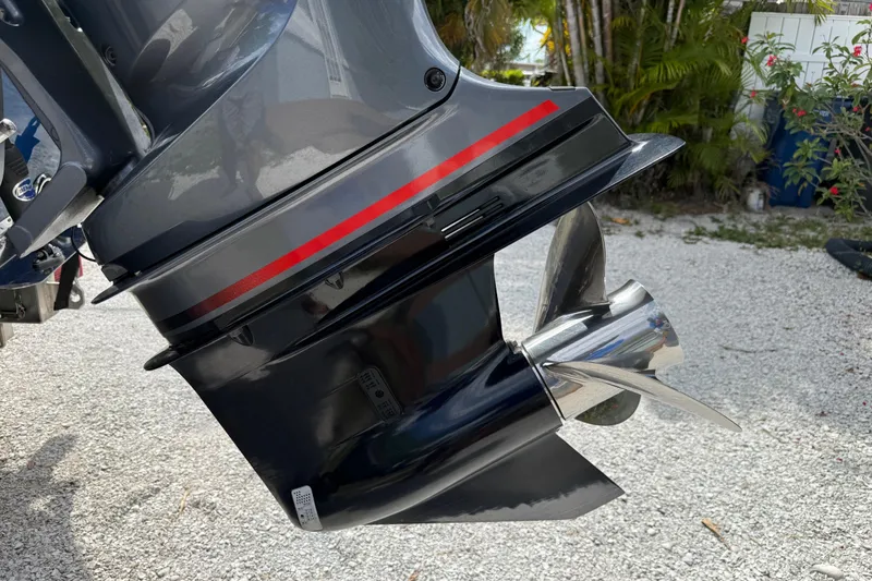 Slide: The Image of 2023 Skeeter SX230 boat motor with propeller, parked on gravel near tropical plants. - 10