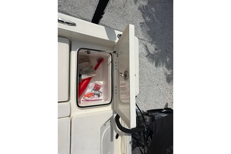 Slide: The Image of Open storage compartment on 2023 Skeeter SX230 boat with safety equipment inside. - 16