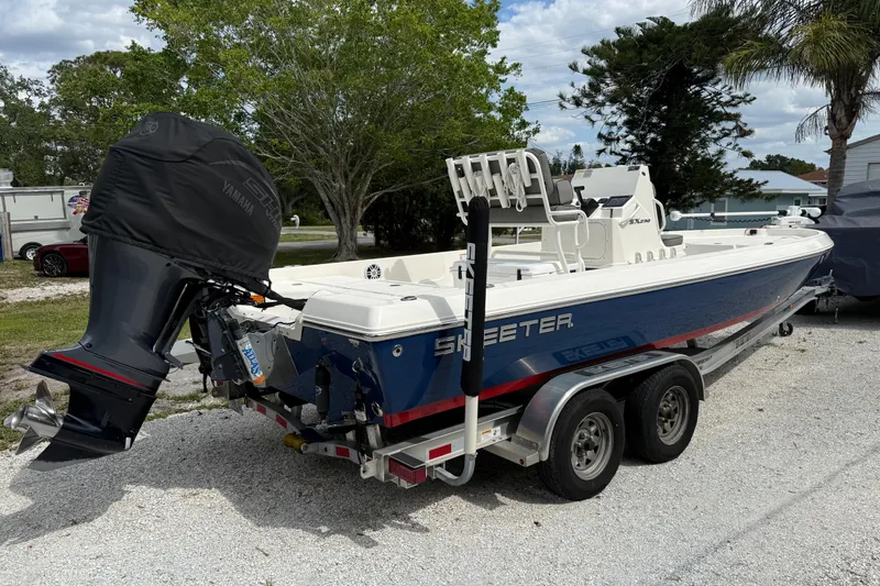 Slide: The Image of 2023 Skeeter SX230 boat on trailer, featuring Yamaha engine, parked outdoors. - 2