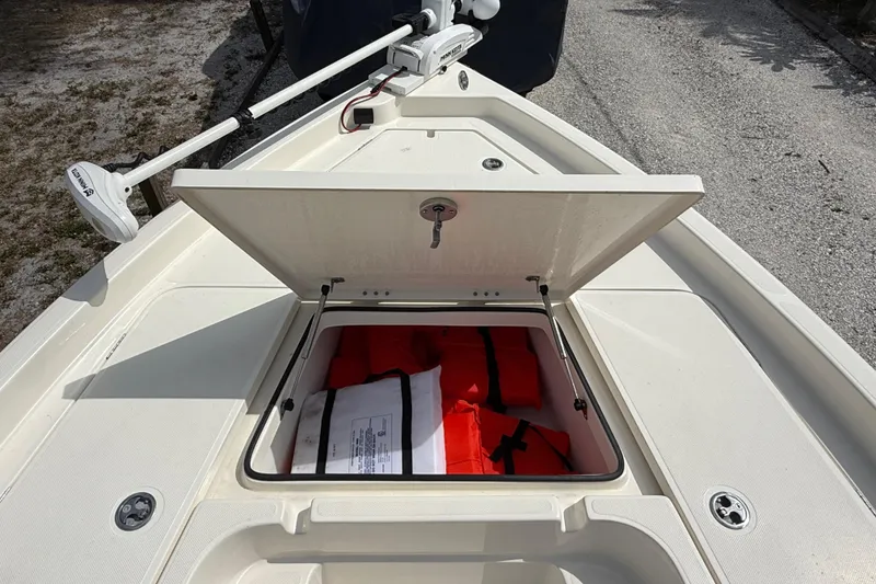 Slide: The Image of 2023 Skeeter SX230 boat storage compartment with life jackets and trolling motor. - 28