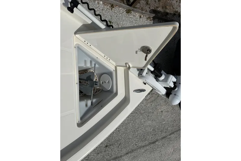 Slide: The Image of 2023 Skeeter SX230 boat anchor compartment with open hatch and visible anchor. - 31