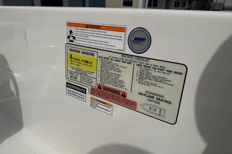 Slide: The Image of Warning and capacity labels on 2023 Skeeter SX230 boat interior. - 34