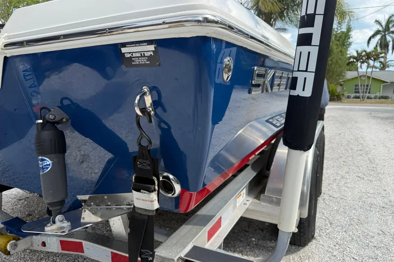 Slide: The Image of 2023 Skeeter SX230 boat on trailer, showcasing sleek blue design and branding. - 37