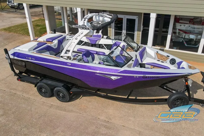 The Image of 2022 Tigé Z3 boat in purple and black on a trailer, parked outside a building. - 0