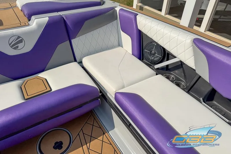 Slide: The Image of 2022 Tigé Z3 boat interior with purple and white seating, featuring cup holders and a speaker. - 13