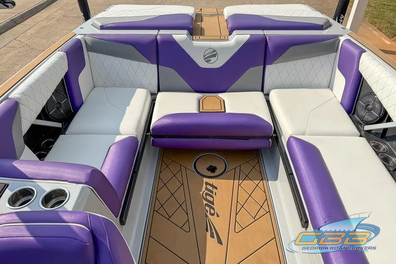 Slide: The Image of 2022 Tigé Z3 boat interior with purple and white seating, featuring cup holders and logo. - 14