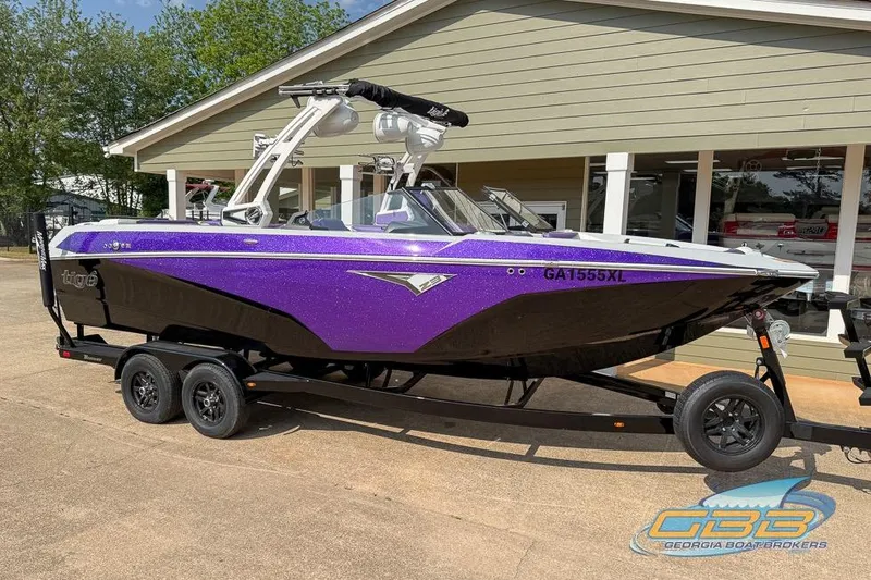 Slide: The Image of 2022 Tigé Z3 boat in purple and black on trailer outside a building. - 17