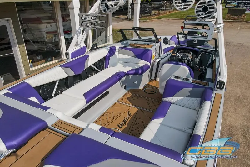 Slide: The Image of 2022 Tigé Z3 boat interior with purple and white seating, modern dashboard, and speakers. - 3
