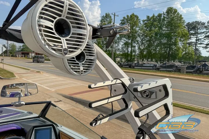 Slide: The Image of 2022 Tigé Z3 boat with tower speakers and wakeboard rack, parked near a road. - 4