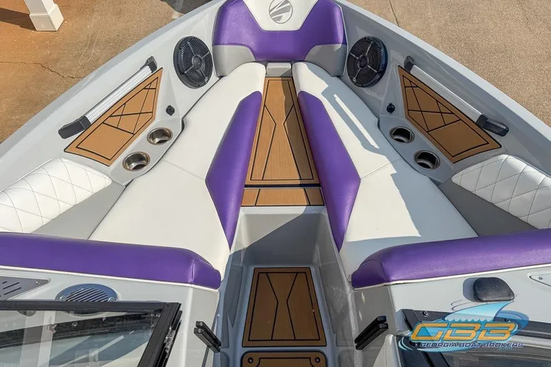 Slide: The Image of 2022 Tigé Z3 boat interior with purple and white seating, wood accents, and cup holders. - 6