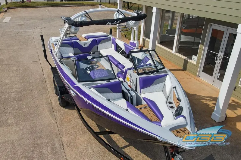 Slide: The Image of 2022 Tigé Z3 boat with purple and white interior, parked on a trailer. - 8