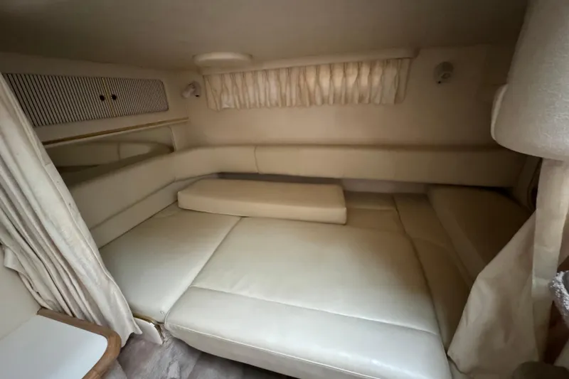 Slide: The Image of Interior cabin of 2000 Sea Ray Sundancer 310 with beige seating and curtains. - 13