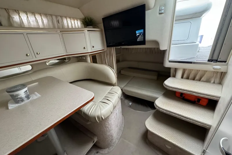 Slide: The Image of Interior of 2000 Sea Ray Sundancer 310 yacht with seating, table, and TV. - 14