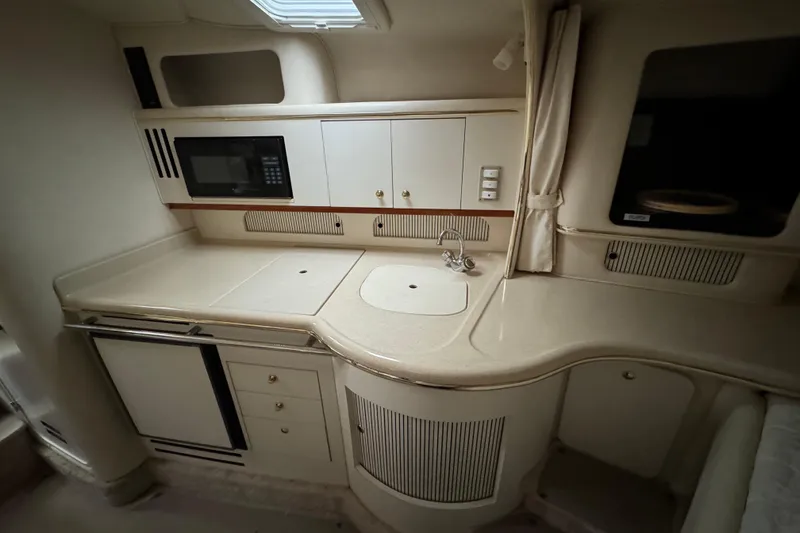 Slide: The Image of Interior of 2000 Sea Ray Sundancer 310 yacht kitchen with sink, microwave, and cabinets. - 17