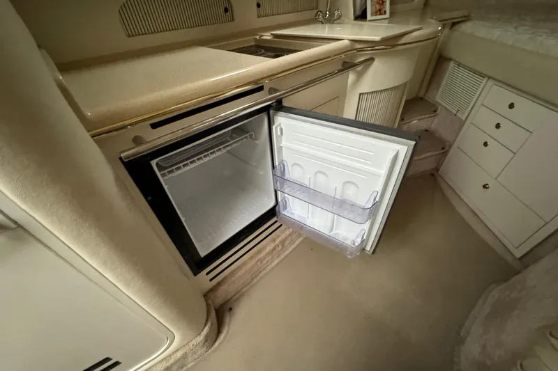 Slide: The Image of Interior of 2000 Sea Ray Sundancer 310 with open mini fridge in cabin. - 18