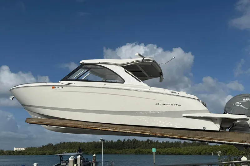 The Image of 2023 Regal LX36 boat on lift against blue sky background. - 1