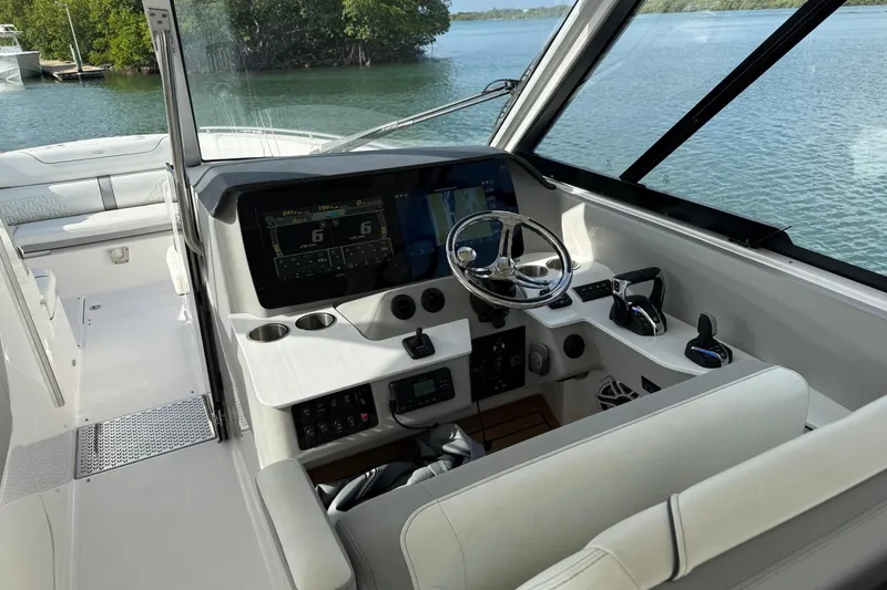 Slide: The Image of 2023 Regal LX36 boat cockpit with modern controls and scenic water view. - 10