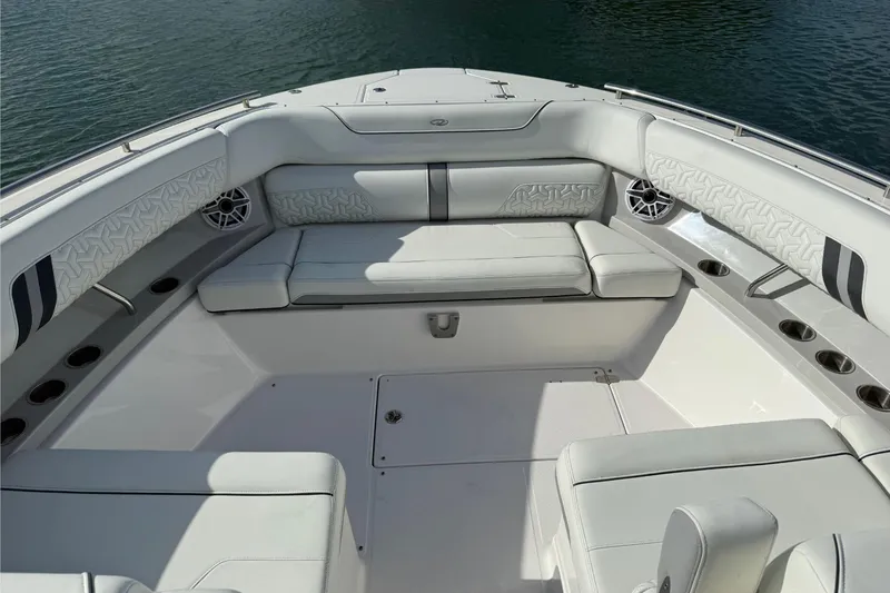 Slide: The Image of Luxurious seating area on 2023 Regal LX36 boat, featuring elegant white upholstery and cup holders. - 14