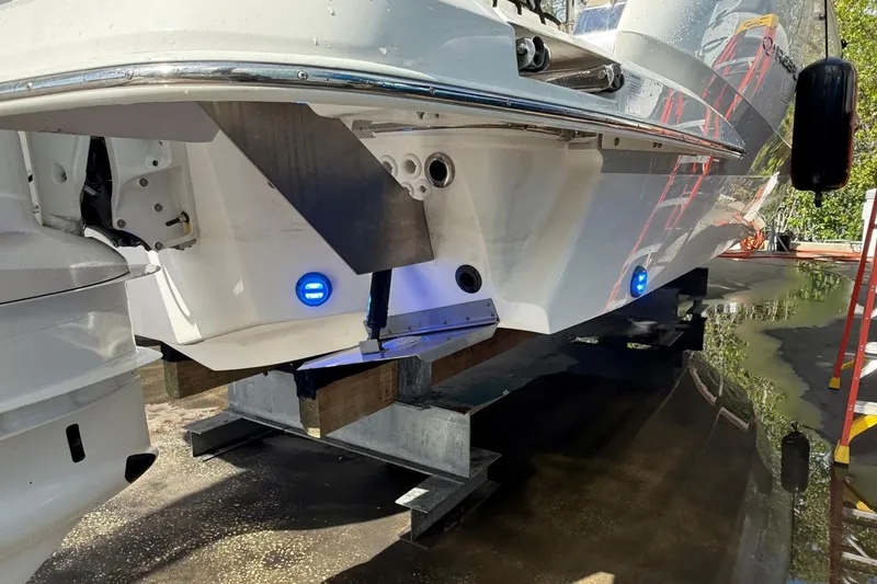 Slide: The Image of 2023 Regal LX36 boat on blocks, showcasing hull and blue underwater lights. - 36