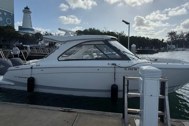 Slide: The Image of 2023 Regal LX36 boat docked at marina with lighthouse in background. - 4