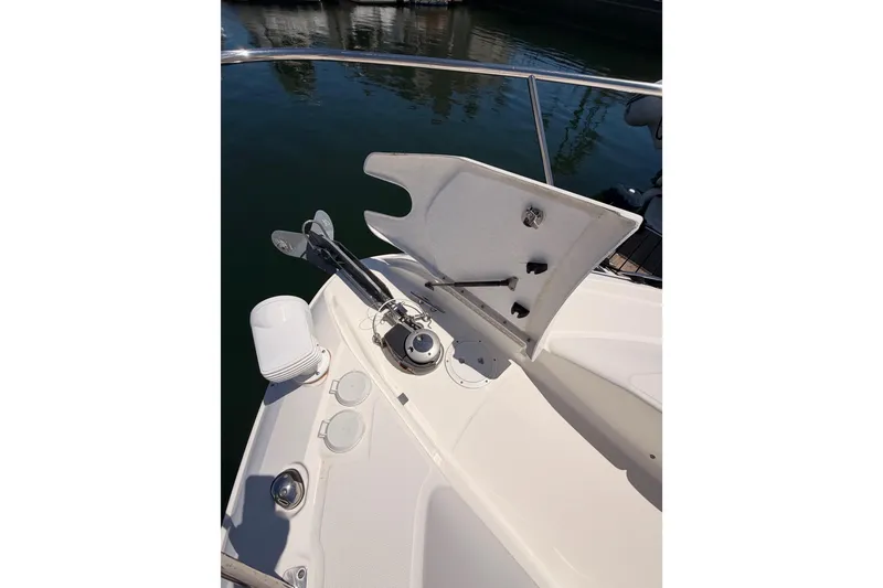 Slide: The Image of 2018 Sea Ray Sundancer 350 Coupe anchor system on deck, docked in calm waters. - 15