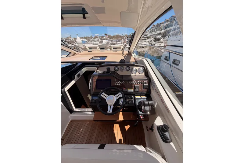 Slide: The Image of 2018 Sea Ray Sundancer 350 Coupe helm with modern controls and wood accents. - 31