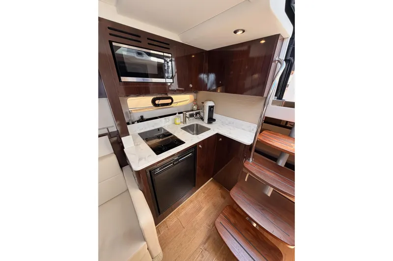 Slide: The Image of Luxurious galley in 2018 Sea Ray Sundancer 350 Coupe with modern appliances and wood accents. - 41