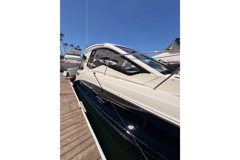 Slide: The Image of 2018 Sea Ray Sundancer 350 Coupe docked, showcasing sleek design and modern features. - 5