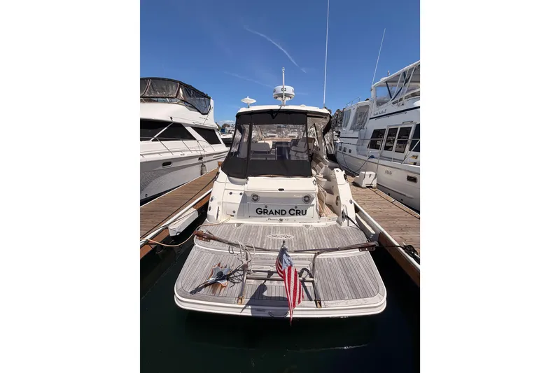 Slide: The Image of 2018 Sea Ray Sundancer 350 Coupe docked at marina, rear view with American flag. - 6