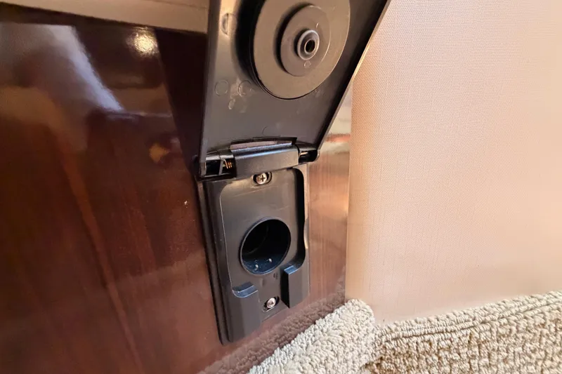 Slide: The Image of Power outlet on 2018 Sea Ray Sundancer 350 Coupe interior, near carpeted floor. - 66